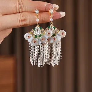 Vintage fan-shaped earrings with pearls, emeralds, and long beaded metal tassels
