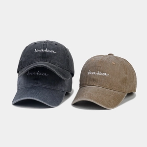 Detail of washed cotton baseball caps with embroidered baba text in grey and khaki colors
