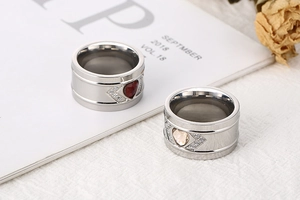 Detailed macro view of wide couple rings with red and gold heart-shaped zircon stones