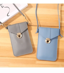 Detail view of gray and light blue PU leather crossbody phone bags with gold twist locks