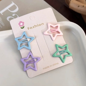 Macro view of four pastel star-shaped hair clips displayed on a stylish fashion card