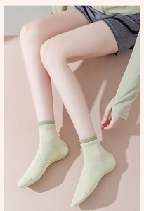 Detail von hellgrünen gerippten Yoga-Socken am Modell mit rutschfester Baumwoll-Stricktextur