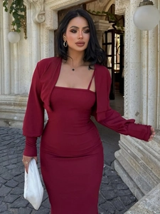 Détail d'une robe moulante bordeaux avec boléro assorti dans un décor extérieur élégant