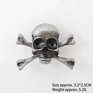Vue détaillée de la broche tête de mort montrant la taille 3,2x2,5cm et le fini antique