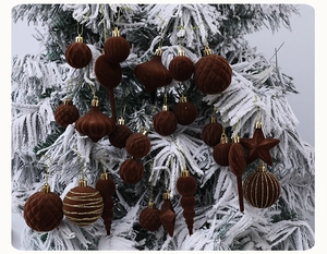 Detail von sortierten schokoladenfarbenen beflockten Weihnachtskugeln an einem Schneebaum
