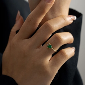 Elegant S925 sterling silver ring with green round stone on a model's ring finger