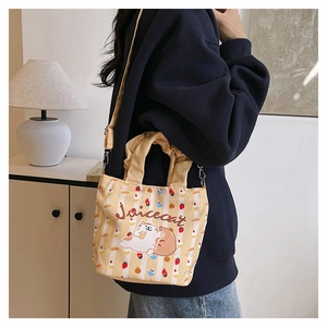 Detail of adjustable strap and handle on cartoon print striped canvas bucket bag