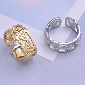 Detail of heart-shaped cut-out rings with textured finish in gold and silver