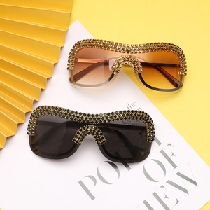 Detailed view of oversized punk sunglasses featuring sparkling rhinestones on metal frames