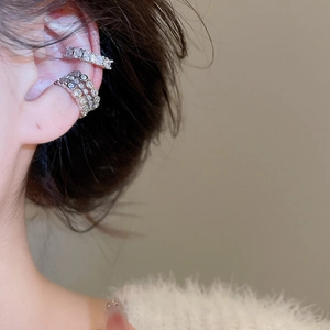 Vue détaillée d'un lot de bagues d'oreilles argentées avec zircon et perles sur l'oreille