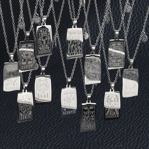 Silver stainless steel zodiac tarot pendants set displayed on black leather background