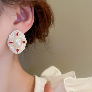 Gros plan sur la boucle d'oreille style palais vintage avec perles et strass rouges