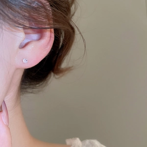 Close-up of a minimalist silver stud earring with a sparkling round cubic zirconia