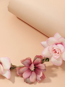 Macro detail of handmade floral headband featuring fabric roses on woven jute rope