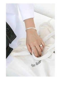 Close-up of S925 silver rings and hammer-textured bracelet with white heart inlay
