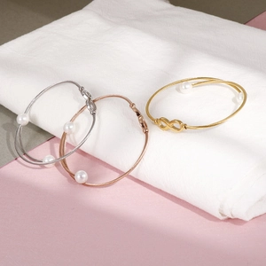 Bracciale a cavo in acciaio con perle e simbolo infinito nei toni argento e oro