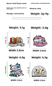 Detailed view of enamel alloy book brooches with flower designs and engraved text