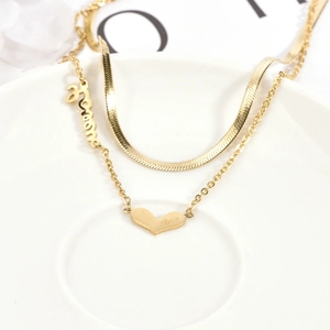 Double-layered gold titanium steel necklace featuring mom and heart pendants on white ceramic