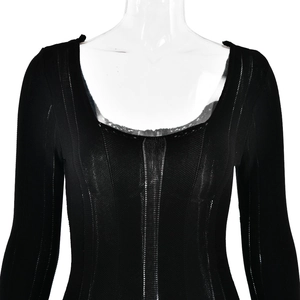 Detail of black long sleeve knit dress featuring a deep U-neck and ribbed texture
