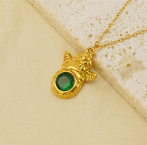 Detail van 18k vergulde engel hanger met groene zirkoon op een vintage halsketting