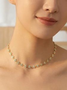 Gros plan d'un collier plaqué or 18k avec marguerites en émail bleu sur le cou
