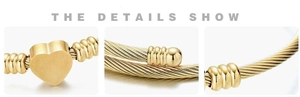 Macro detail of gold stainless steel twisted wire bracelet with a polished heart charm