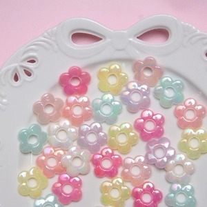 Colorful mixed flower beads with pearl luster on a white ceramic tray for DIY jewelry