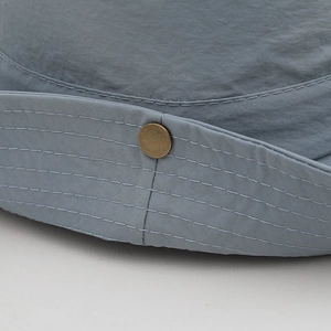 Detailed close-up of mountain hat brim with parallel stitching and vintage bronze snap button