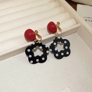 Detailansicht der rot-schwarzen gepunkteten Blumen-Ohrclips mit goldfarbenem Finish