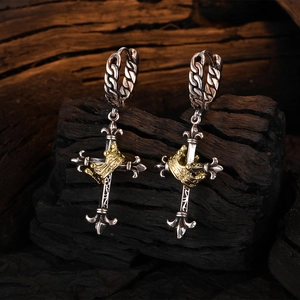 Vintage Thai silver cross earrings with gold crown accents on dark wood background