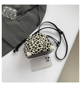 Detailed top view of leopard print drawstring bucket bag with vintage metal corners and strap