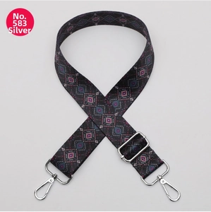 Detail of adjustable polyester bag strap with ethnic geometric pattern and silver hooks