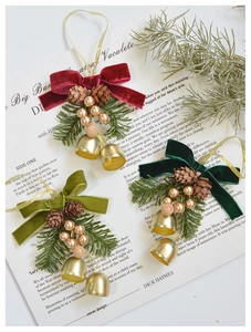 Close-up of velvet bow Christmas bells with pine needles and cones on vintage paper