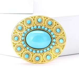 Detailed macro view of the vintage oval gold brooch featuring turquoise gemstones and filigree
