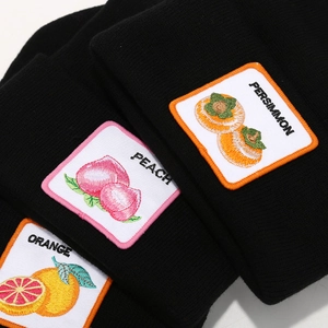 Black knit beanie hats with orange, peach and persimmon fruit embroidery patches