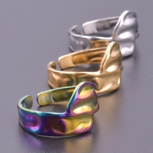 Detailed view of wave textured open rings in silver, gold and rainbow titanium steel