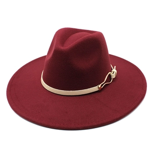 Detail of burgundy wool fedora featuring cream leather band and gold metal buckle