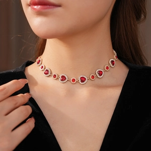 Dettaglio di una collana vintage dorata con cuori rossi e pavé di diamanti brillanti