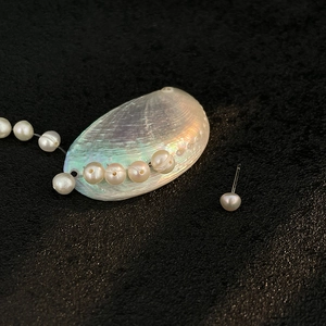 Elegant freshwater pearl drop earrings on natural shell with minimalist needle design
