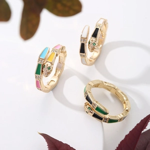 Detailed macro view of colorful enamel snake rings with green zircon eyes in gold finish