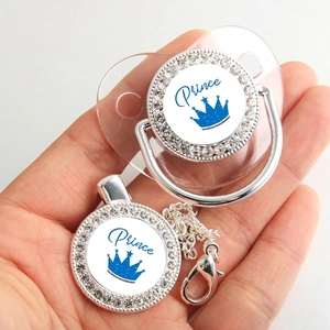 Close-up of baby pacifier with blue crown rhinestones and matching prince chain clip