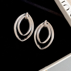 Vue macro de boucles d'oreilles géométriques doubles ovales en argent sur velours