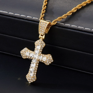 Vue détaillée du pendentif croix dorée serti de zircons avec chaîne torsadée hip-hop