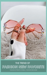 Dettaglio di occhiali da sole senza montatura sfumati rosa con fiori di strass lucidi