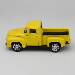 Side view of a vintage yellow alloy pickup truck model with silver wheels and black bed
