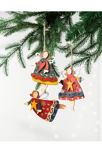 Detailed close-up of three colorful wooden angel ornaments hanging on a green Christmas tree