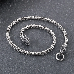 Detalle de collar de cadena bizantina de acero titanio 6mm con cabezas de dragón.