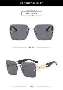 Close-up of gold chain-link arms and gradient black lenses on rimless square sunglasses
