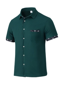 Detail of waffle texture and bird print on dark green short sleeve shirt pocket