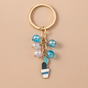 Close-up of beaded cactus keychain with LOVE text on gold, blue and white pots